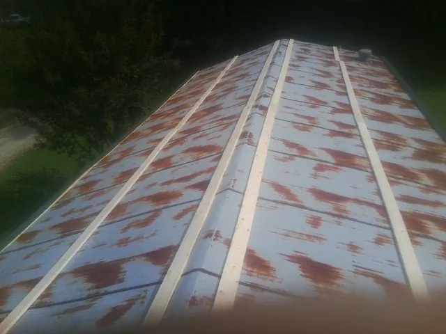 Rusted metal roof panels with new wood purlins before replacement — Storm Damage Roof Repair in Pulaski by Roofing Brothers