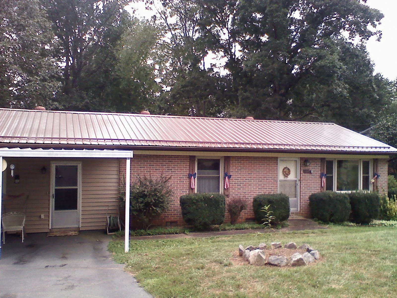 Bronze metal roof and carport on a brick ranch home — Roof Repair work by our crew in Pulaski